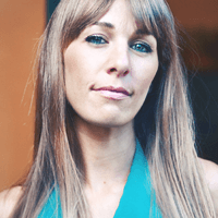 Portrait of a confident woman with straight hair and green top.